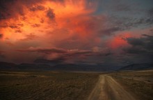 Road Path On A Desert Wild Mountain Plateau At The Background Of The Hills Under A Dramatic Sunset Colorful Sky With Illuminated Red Pink Purple Clouds Kurai Altai Mountains Siberia Russia