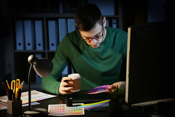 Canvas Print - Young male designer working in office