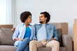© Syda Productions - happy couple sitting on sofa and talking at home