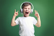 © Africa Studio - Cute little boy in headphones listening to music on color background