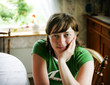 © Astrakan Images - Portrait of smiling teenage girl sitting in living room