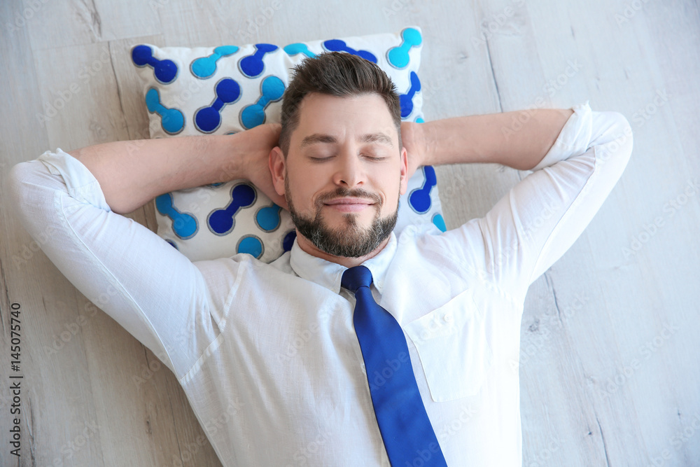 Happy young man lying on floor and resting