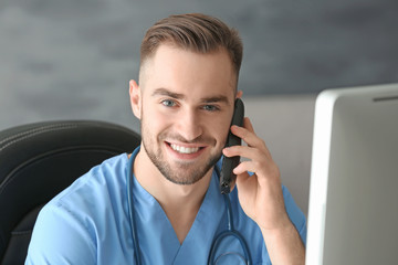 Poster - Young medical assistant talking by telephone while working in office