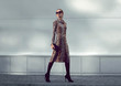 Fashion woman model wearing a leopard dress is walking in a evening city
