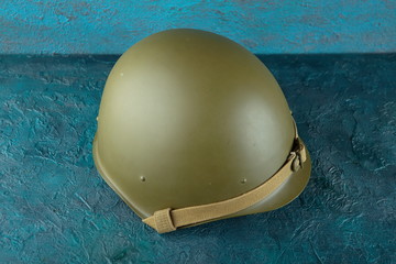 Old military helmet from the Second World War on cement background.