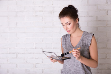 Wall Mural - portrait of beautiful girl applying make up over white wall