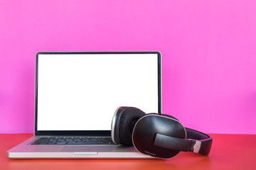 modern laptop with blank screen and headphones on colorful background.