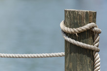 Wooden Pier Post And Rope Tied To It With A Shallow Depth Of Field