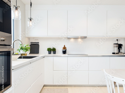 Zdjęcie XXL stylowe wnętrze kuchni z białymi szafkami i blatem kuchennym