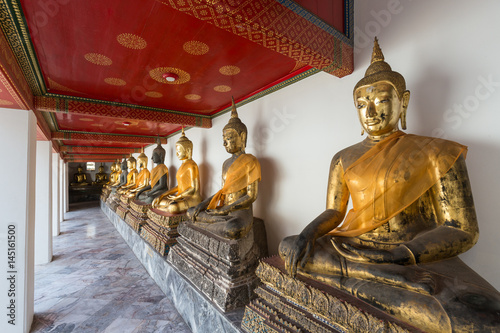 Several old statues of sitting Buddha with a cloth at the Wat Pho (Po) temple complex in Bangkok, Thailand Wallpaper Mural