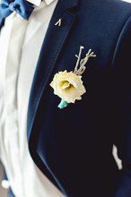 Details Of Male Wedding Clothes. Beautiful Boutonniere Pinned On Man In Blue Suit, White Shirt And Blue Bow Tie.