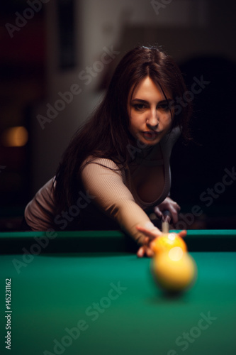 Zdjęcie XXL Młoda atrakcyjna kobieta bawić się bilard w klubie.