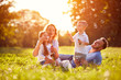 © luckybusiness - Family with children blow soap bubbles