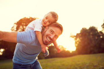 Wall Mural - Father piggyback his son outside