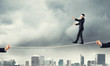 © adam121 - Business concept of risk support and assistance with man balancing on rope