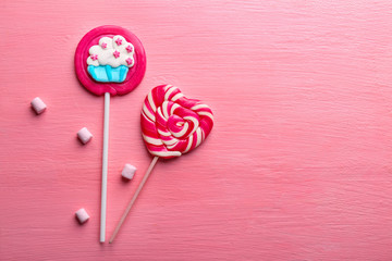 Wall Mural - Tasty lollipops on color background