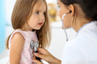 © rogerphoto - Doctor examining a little girl by stethoscope