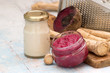  Root of horseradish and beets.   Root of horseradish, beets, two jars with seasoning and a metal grater on an old wooden table.