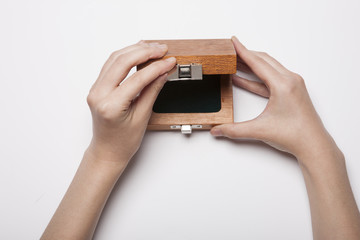 woman hand hold a wood case(package) isolated white.