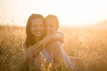 Wall Mural - Smiling mother and daughter hugging each other