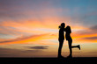 © Johnstocker - Silhouette young couple in love enjoy good time together during sunset.