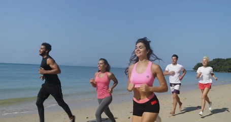 Wall Mural - people group running on beach young men and women athlete jogging training outdoors exercising on se