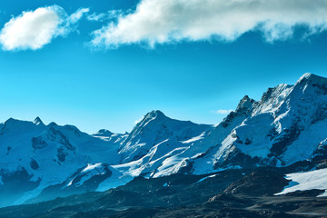 Wall Mural - Snow capped mountains. Summits of the mountains. View of the Alpine mountains at the sunrise. Trek near Matterhorn mount.