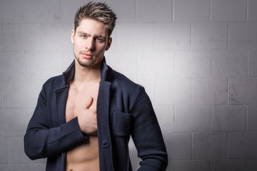 Photo of handsome attractive man or boy posing for the camera with the hand on the chest.