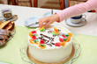 Dłoń dziewczynki zabiera ozdoby z tortu urodzinowego.