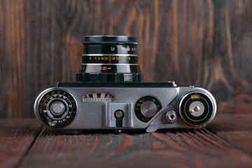 The old rangefinder camera on a wooden background.