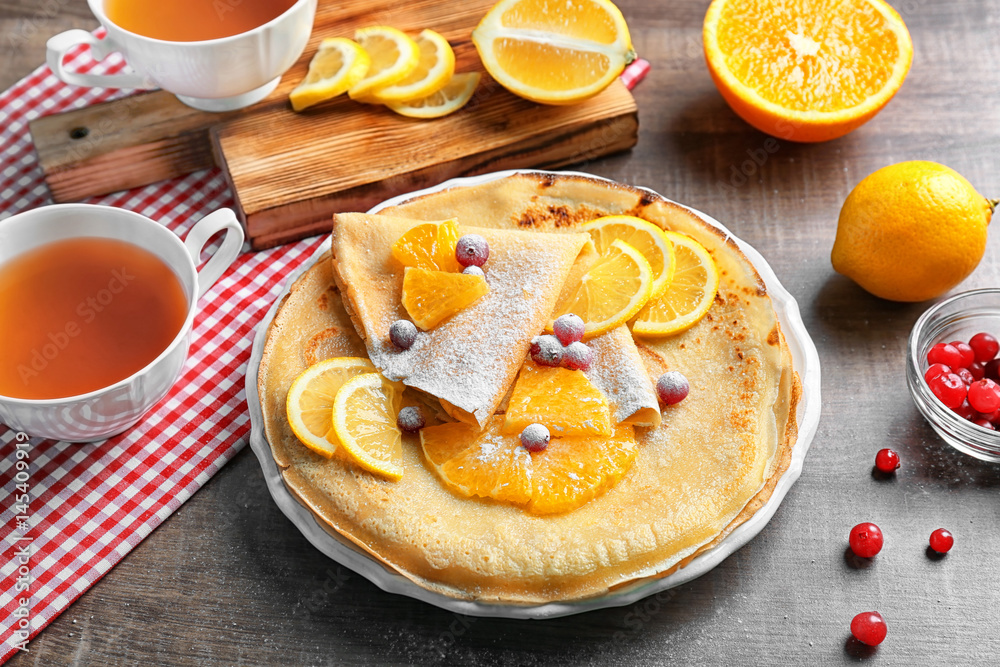 Delicious pancakes with orange and  cranberry on plate
