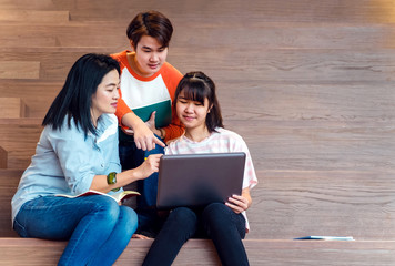 Poster - Groups of asian teenage students using laptop computer studying together at university stair library