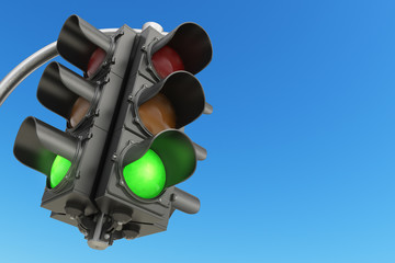 Traffic light with green color on blue sky background.