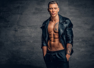 Wall Mural - A man with tattoo on a chest, dressed in a black leather jacket.