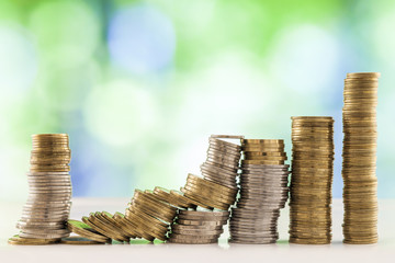 Growing coins stacks with green and blue sparkling bokeh background. Financial growth, saving money, business finance wealth and success concept.