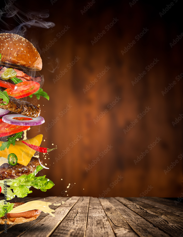 Obraz Big tasty burger with flying ingredients. fototapeta, plakat