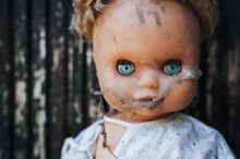 The Face Of An Old Doll In A Cobweb.