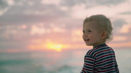 a little cute child smiling on the summer beach 50fps slow motion . summer vacation florida boy's po