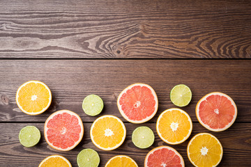 Sticker - Colorful citrus halves on wooden table. Food background