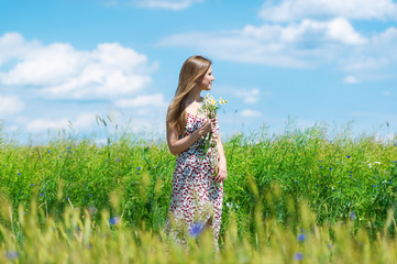 Beautiful woman enjoying cornflower field and blue sky