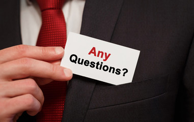 Poster - businessman putting a card with text any questions in the pocket