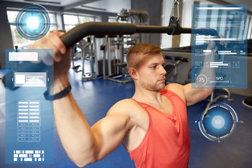 man flexing muscles on cable machine gym