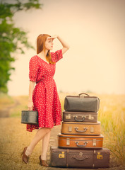 Sticker - photo of beautiful young woman with suitcases on the wonderful wheat field background