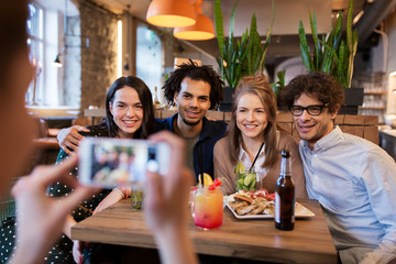 Canvas Print - friends with smartphone photographing at cafe