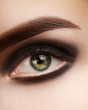 © marinafrost - Beautiful macro photo of woman eye with black smoky makeup. Perfect shape eyebrows. Cosmetics and make-up