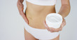 © Kitreel - Young girl smears cream her beautiful, perfect body(waist), on a white background. Concept: vegetarian, diet, proper nutrition, spa procedures, fresh, fitness, bio products, body care, perfect skin.
