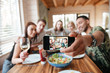 © Drobot Dean - Group of friends having dinner and taking selfie with smartphone