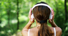 A Woman In The Green Wearing Headphones Listening To Music, Singing, Dancing And Having Fun With An Air Carefree. The Music Gives Him The Energy To Sing And Be Happy. Music Makes Flying Imagination	