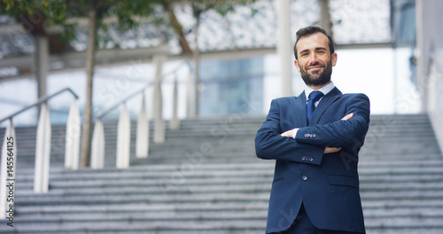 Fotomural A man in a suit, looks in camera and smiles proud and sure of himself