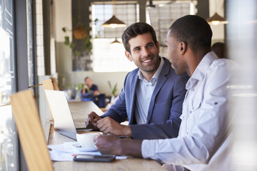 Two Businessmen Having Informal Meeting In Coffee Shop